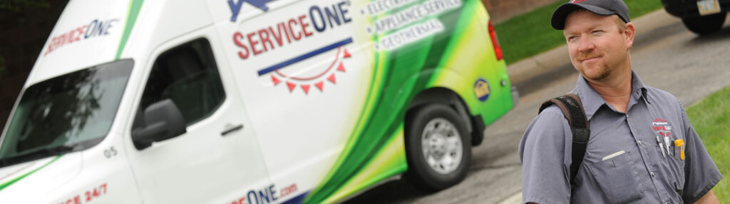 A ServiceOne tech next to a van